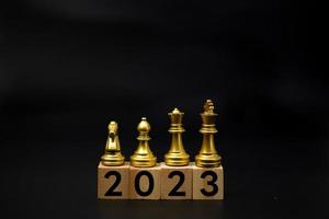 ajedrez en texto de cubo de madera 2023 año nuevo. concepto de éxito de crecimiento de estrategia de inversión empresarial. foto