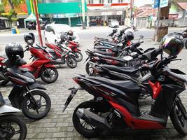 Mataram city, Lombok island, January 10, 2023. Rows of motorbikes parked in front of a shop in the city of Mataram, Lombok island, Indonesia photo