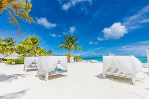 increíble escena de playa tropical con dosel blanco y cortina para un lujoso concepto de relajación de verano. cielo azul con arena blanca para el fondo del paisaje de la playa soleada y vacaciones de verano o diseño de vacaciones foto