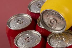 Cold red soda cans with a yellow one for conceptual use photo