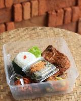 nasi kotak o caja de arroz o lonchera, popular como sego berkat con pollo, patata, huevo, verduras y sambal.