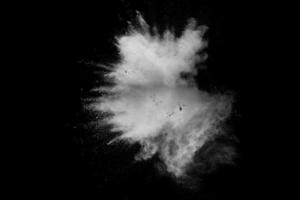 Formas extrañas de nube de explosión de polvo blanco sobre fondo oscuro. Salpicaduras de polvo blanco lanzadas sobre fondo negro. foto