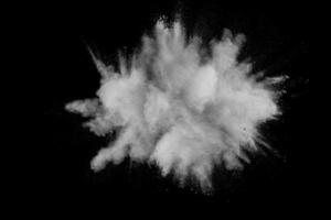 Formas extrañas de nube de explosión de polvo blanco sobre fondo oscuro. Salpicaduras de polvo blanco lanzadas sobre fondo negro. foto