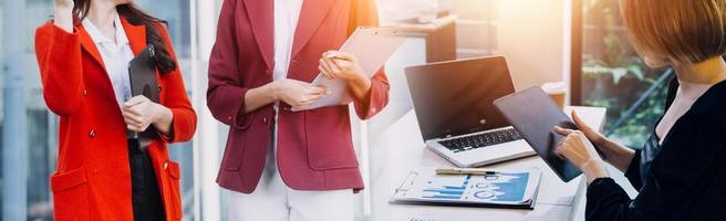 hombre de negocios y equipo analizando la tarea financiera de los estados financieros. con teléfono inteligente y computadora portátil y tableta. concepto de gestión de riqueza foto