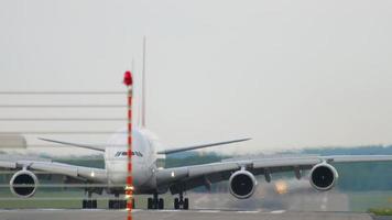 dusseldorf, alemania 23 de julio de 2017 - pasajero airbus a380 de emirates rodando después de aterrizar en la terminal del aeropuerto de dusseldorf, vista frontal. concepto de turismo y viajes video