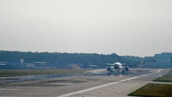 The wide bodied aircraft lands on runway with smoke video