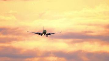 silhuett av flygplan flygande i orange solnedgång himmel med moln upplyst förbi miljö Sol. underbar clouds med flygplan. flyg av plan med blinkande lampor på solnedgång video