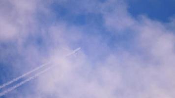 l'avion vole haut dans le ciel une traînée blanche. une trace blanche de condensation derrière un avion en vol. la traînée de condensation de l'avion est haute dans le ciel. video