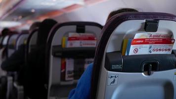 versmallen gangpad visie binnen vliegtuig cabine met vol van passagier terwijl ontspannend, mensen reist Aan Jet vlak met onherkenbaar passagiers video