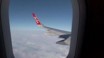 view of sky from inside  airplane cabin while flying over cloud sky scape through the window with wing view in daytime