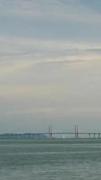 verticaal timelapse bewolkt zonsondergang straal over- penang brug over- oceaan Verbinden penang eiland met zonsondergang vanille lucht tijd, beroemd mijlpaal in Maleisië video