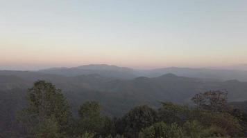 vista del paisaje en el camión en movimiento de la vista de la puesta de sol de la cordillera con algunas nubes mientras se pone el sol en la montaña de la colina en invierno video