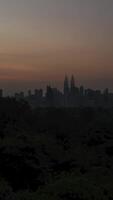 vertical timelapse landscape view of kuala lumpur city center downtown district area with many skyscraper building highrise modern style towers with beautiful vanilla sundown sunrise twillight sky video