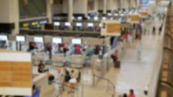 fora de foco turva de pessoas lotadas filas de passageiros no aeroporto esperando e check-in na área do balcão, campo aberto, multidão no aeroporto internacional video