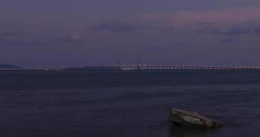raio do sol nublado de timelapse sobre a ponte de penang sobre o oceano conectando a ilha de penang com o tempo do céu de baunilha do pôr do sol, famoso marco na malásia video