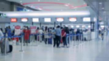 hors de la mise au point floue des lignes de passagers bondées de personnes dans l'aéroport attendant et s'enregistrant au comptoir d'enregistrement, pays ouvert, foule à l'aéroport international video
