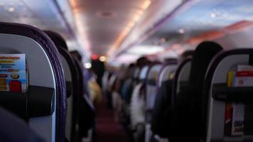 narrow aisle view inside airplane cabin with full of passenger while relaxing,People travels on jet plane with unrecognizable passengers video