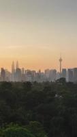 timelapse vertical paysage vue du centre-ville de kuala lumpur quartier du centre-ville avec de nombreux gratte-ciel bâtiment tour de style moderne tours avec beau coucher de soleil vanille lever du soleil ciel crépusculaire video