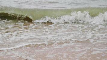 vague de mousse au ralenti sur la plage. nuageux pluvieux. temps nuageux et pluvieux. rayong, thaïlande video
