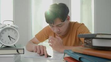 asiatische studenten haben angst wegen prüfungen, männliche bereiten sich auf prüfungen vor und lernen unterricht in der bibliothek. Stress, Verzweiflung, Eile, missverstandenes Lesen, entmutigt, Erwartung, Wissen, müde