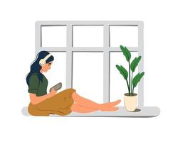 A young woman sits on the window and listens to music on headphones. Music lover. vector