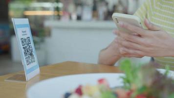 vrouw gebruik smartphone naar scannen qr code naar betalen in cafe restaurant met een digitaal betaling zonder contant geld. Kiezen menu en bestellen accumuleren korting. e portemonnee, technologie, betalen online, credit kaart, bank app. video