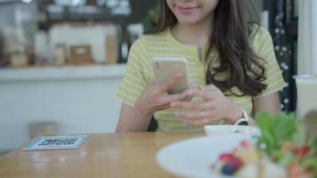 Woman use smartphone to scan QR code to pay in cafe restaurant with a digital payment without cash. Choose menu and order accumulate discount. E wallet, technology, pay online, credit card, bank app. video