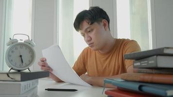 Asian student man have anxiety because of exams, male prepare for test and learning lessons in the library. stress, despair, haste, misunderstanding reading, discouraged, expectation, knowledge, tired video