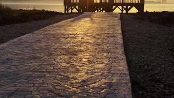 Holzsteg und Meer im Sonnenuntergang video