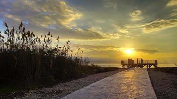 Holzsteg und Meer im Sonnenuntergang video