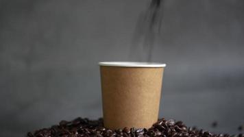 Pour coffee beans into a brown paper cup and scattered on table video