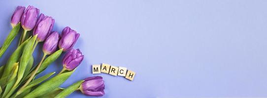 Purple bouquet of flowers tulips background with with the word march on veri peri background. photo