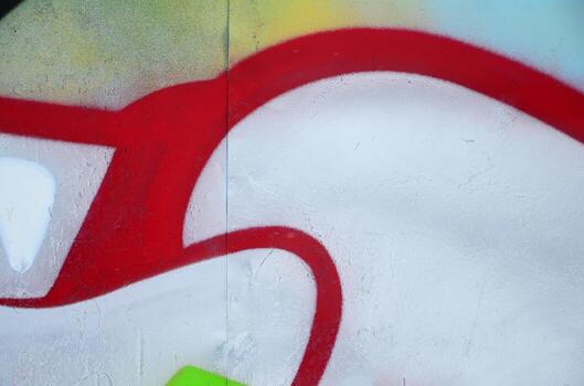 Close-up fragment of a graffiti drawing applied to the wall by aerosol paint. Background image of a modern composition of lines and colored areas. Street art concept photo