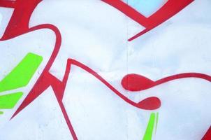 Close-up fragment of a graffiti drawing applied to the wall by aerosol paint. Background image of a modern composition of lines and colored areas. Street art concept photo