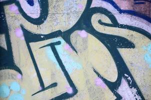 Close-up fragment of a graffiti drawing applied to the wall by aerosol paint. Background image of a modern composition of lines and colored areas. Street art concept photo