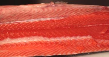 fresco salmone filetto bugie su un' chopping tavola nel il cucina per Sushi fabbricazione. - panning tiro video