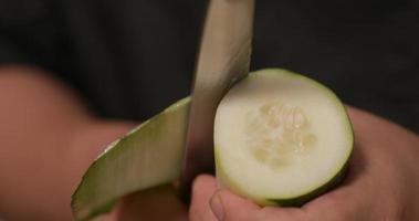 itamae pelar pepino a lo largo para rollos de sushi japonés en la cocina. - fotografía de cerca video