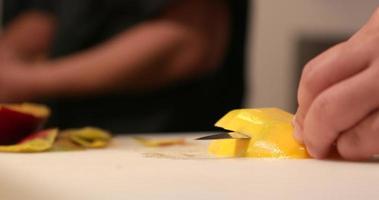 Chef Slicing Ripe Mango Horizontally Using Sharp Knife At The Kitchen. - Close Up Shot video