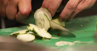 Chef's Hand Chopping Cucumber Using A Sharp Knife In The Kitchen Of A Restaurant. - close up shot video