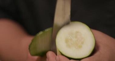 éplucher le concombre frais avec un couteau de chef pour un rouleau de sushi. - photo en gros plan video