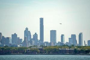 vista del paisaje urbano de nueva york desde la isla de la libertad del río hudson foto