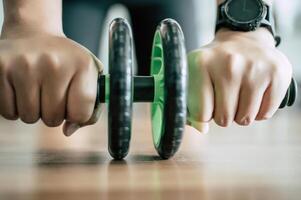 Young fat man workout with ABS hand-roller photo