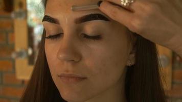 pincel de maquiagem penteia as sobrancelhas jovem close-up video