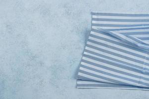 Blue stone table with blue striped napkin tablecloth. Top view mock up, copy space photo