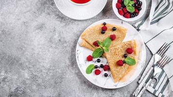 Delicious Crepes Breakfast. Orthodox holiday Maslenitsa. Pancakes with berry black currant raspberry photo