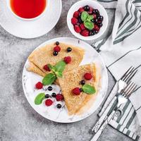 Delicious Crepes Breakfast. Orthodox holiday Maslenitsa. Pancakes with berry black currant raspberry photo