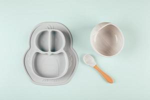 Grey silicone dishware on background. Serving baby, first feeding concept. Flat lay, copy space photo