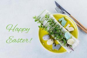 Festive table setting for holiday Easter dinner on light concrete table with copyspace. Spring Holiday Card Concept. Top view, copy space photo