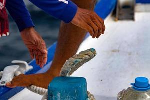 hombre negro migrante pies y manos detalle sin zapatos en el barco foto