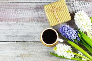 Mother's day or Woman's Day Concept. Hyacinth flowers, gift present, cup of coffee on light concrete background. Spring Greeting card. Flat lay, top view, copy space. Mockup concept. photo